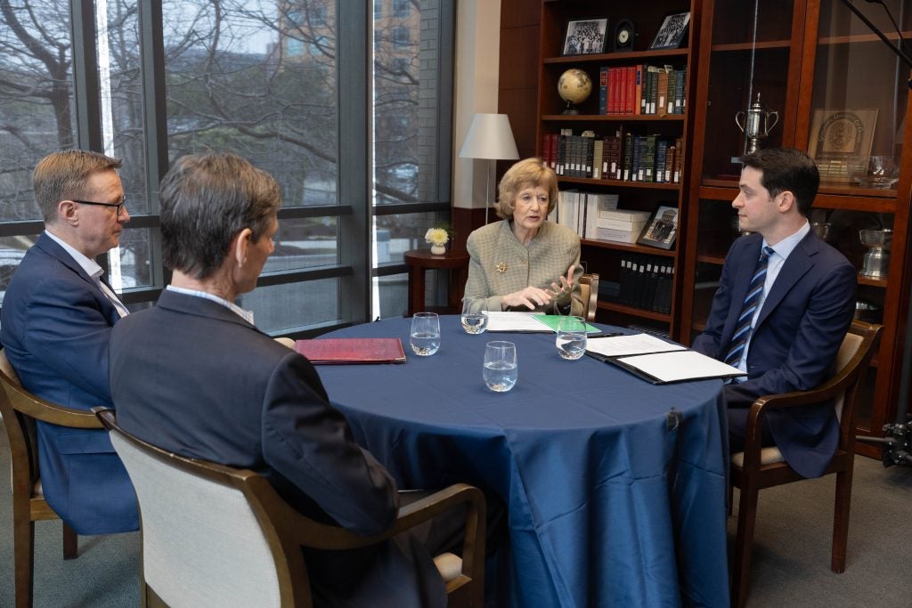 Four people sitting around a table and speaking