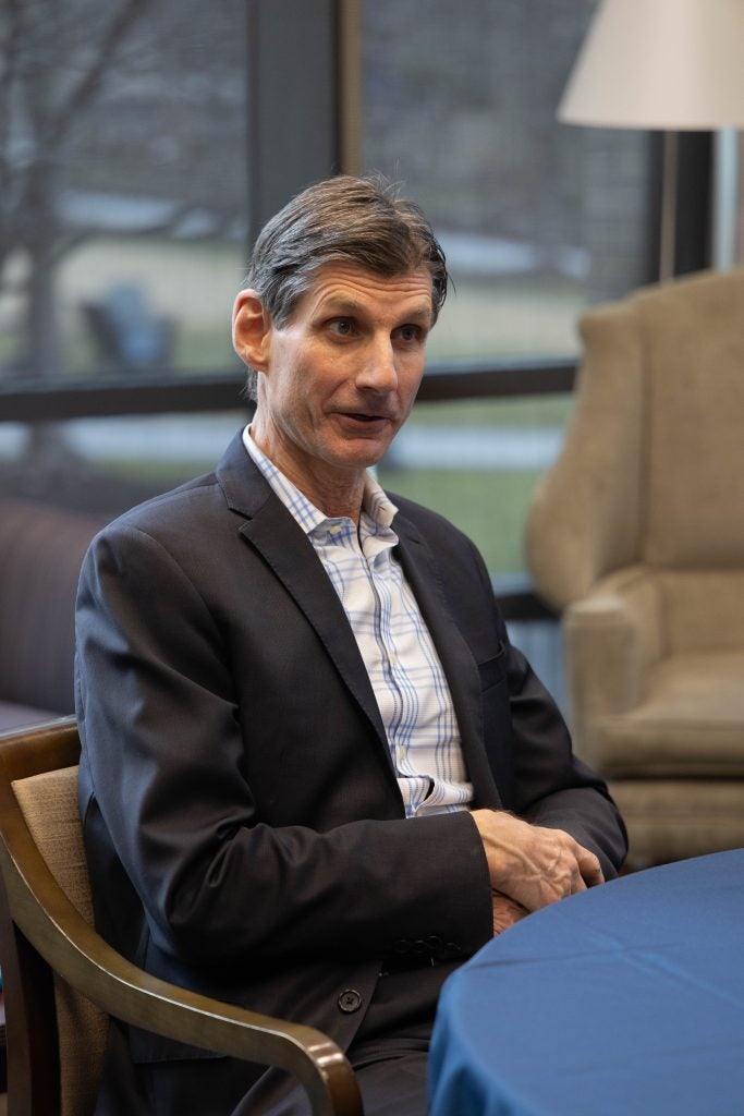 A man sitting at a table, speaking