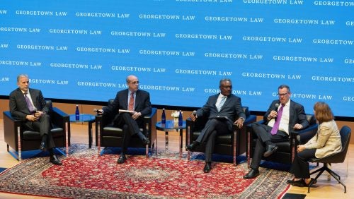 Five panelists sit on the stage in Hart Auditorium