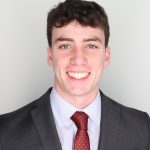 Headshot of Michael Miele, wearing a suit and smiling