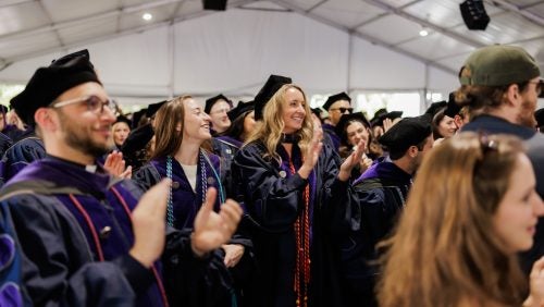 Students standing and applauding from the crowd at Commencement 2025.